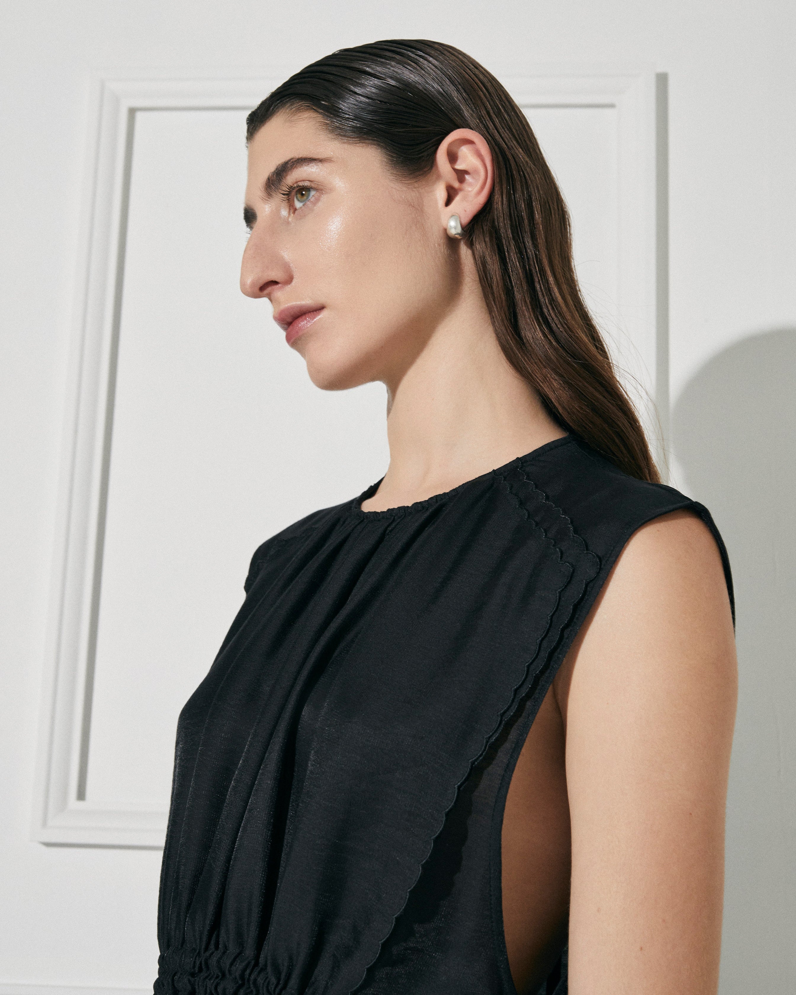 The Facile black maxi dress in Lyocell by Australian designer PALMA MARTÎN is beautifully lightweight and versatile. Featuring delicate scalloped edge detail.