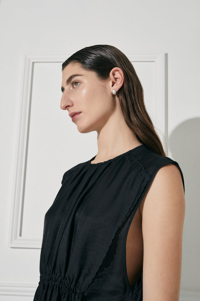 The Facile black maxi dress in Lyocell by Australian designer PALMA MARTÎN is beautifully lightweight and versatile. Featuring delicate scalloped edge detail.
