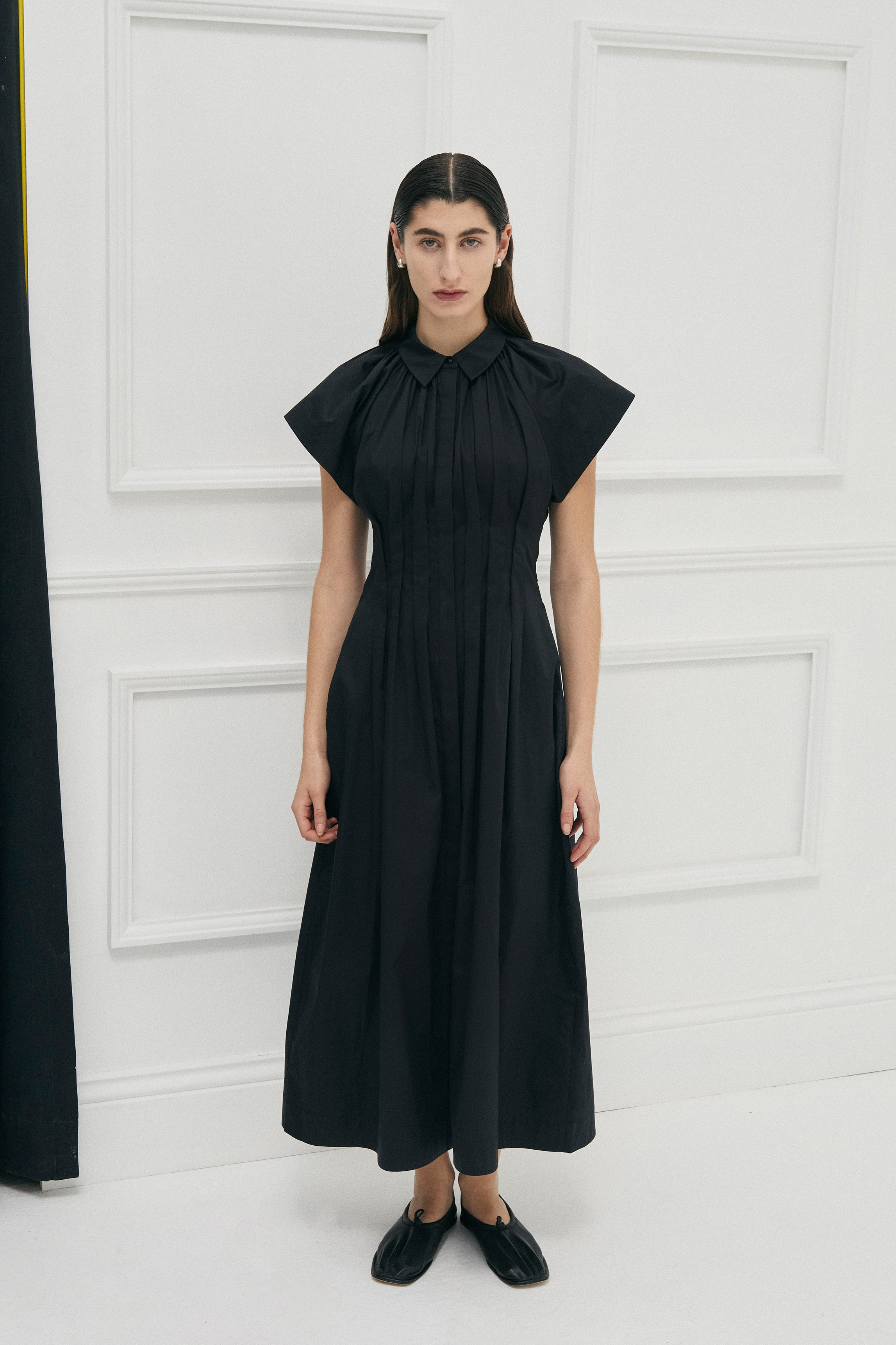 Unchartered shirt dress in Black Cotton by Australian Designer PALMA MARTÎN.  This long black dress style is uniquely tapered at the waist with pleats giving a flattering silhouette. 