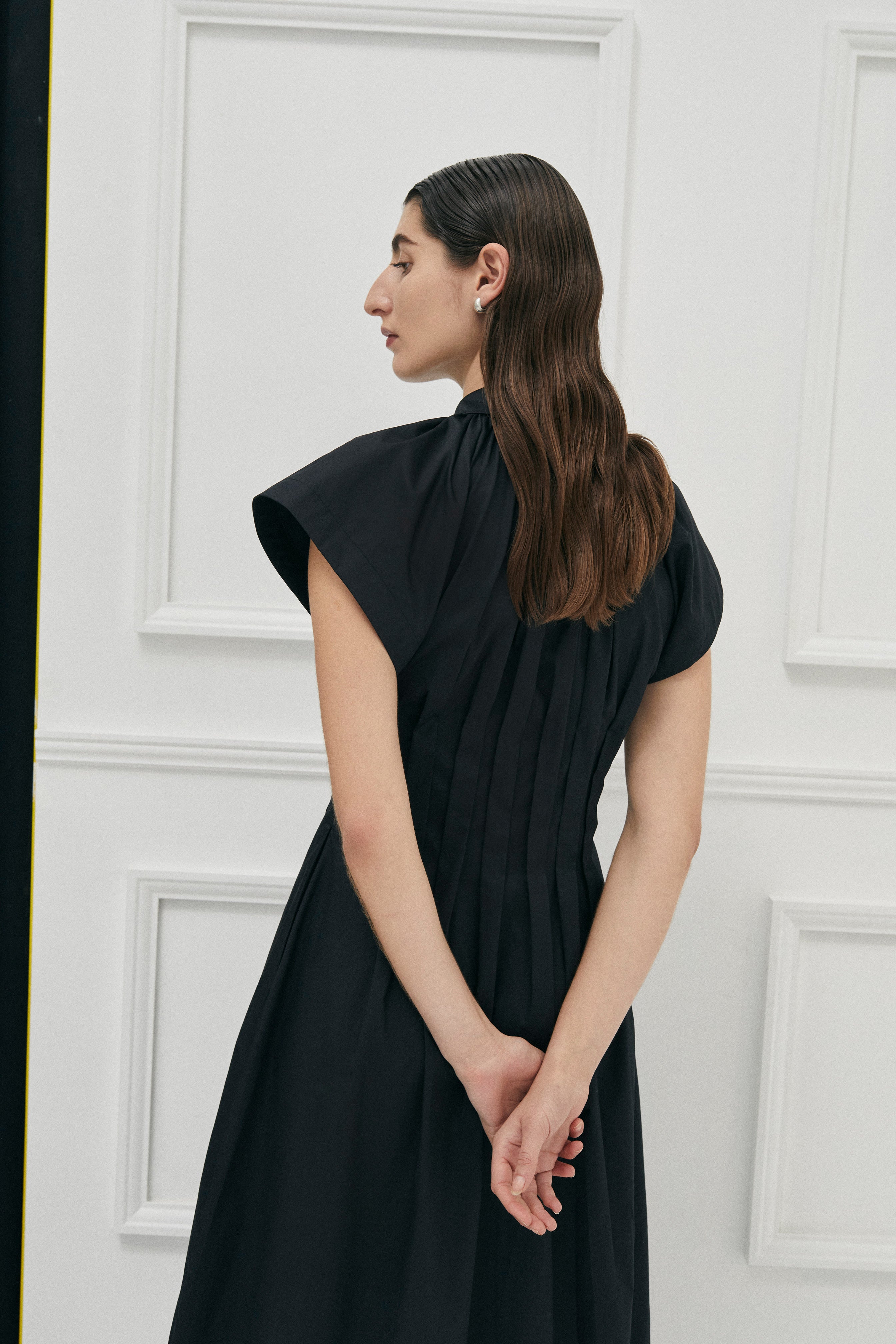 Unchartered shirt dress in Black Cotton by Australian Designer PALMA MARTÎN.  This long black dress style is uniquely tapered at the waist with pleats giving a flattering silhouette. 